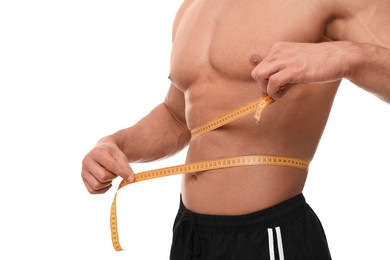 Photo of Athletic man measuring waist with tape on white background, closeup. Weight loss concept