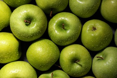 Photo of Ripe green apples with water drops as background, top view