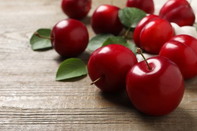 Photo of Fresh ripe cherry plums on wooden table, closeup