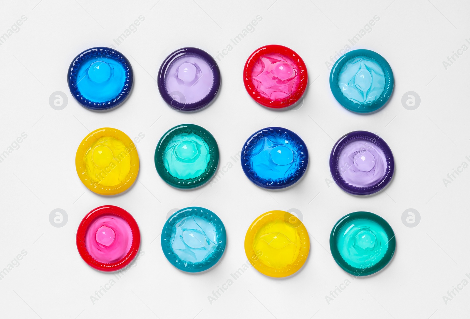 Photo of Colorful condoms on white background, flat lay. Safe sex