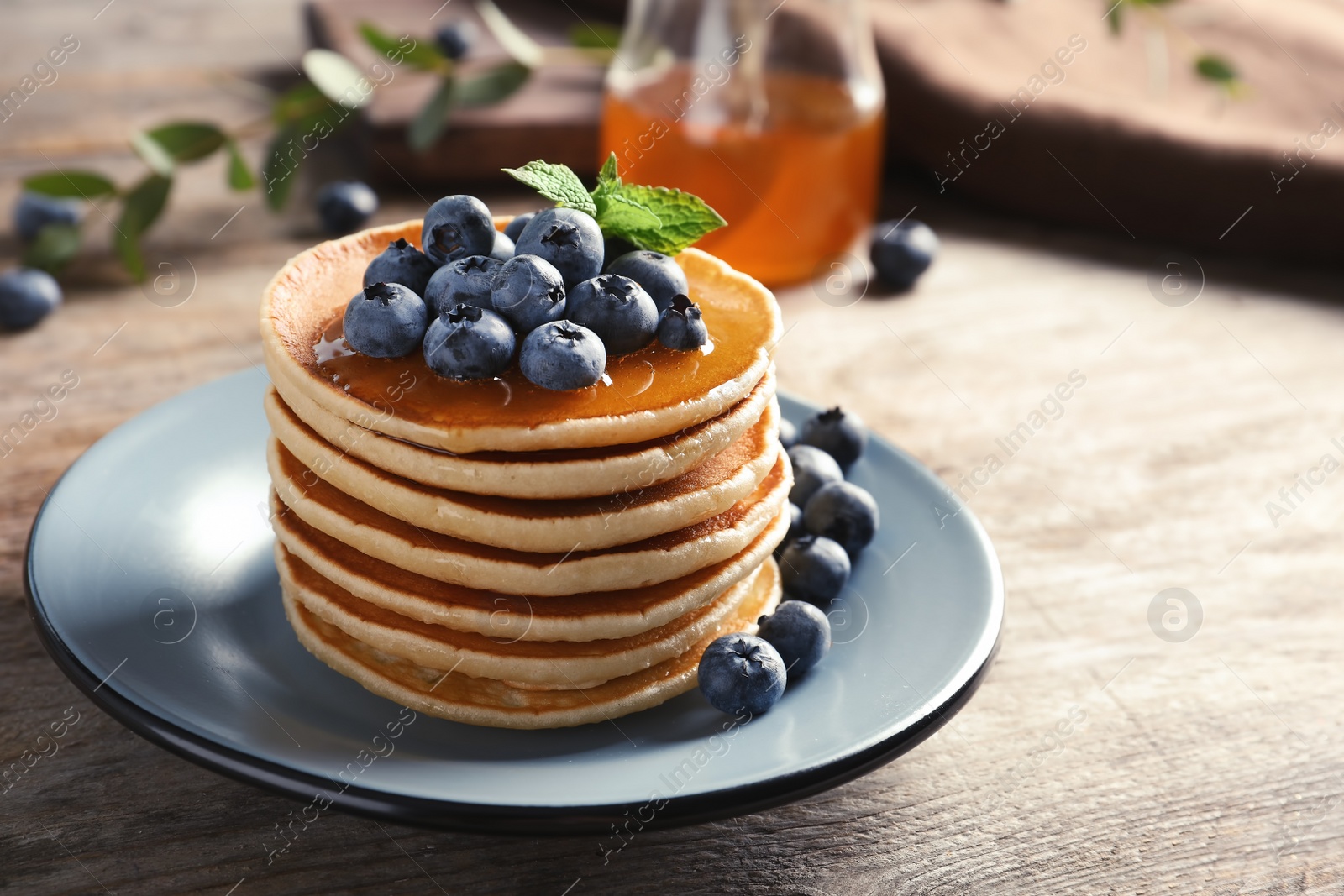 Photo of Plate with pancakes and berries on wooden table