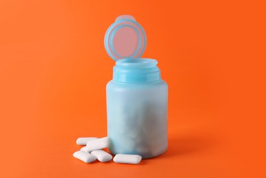 Photo of Jar with chewing gums on orange background