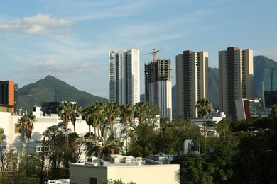 Photo of Picturesque view of mountains and city with skyscrapers