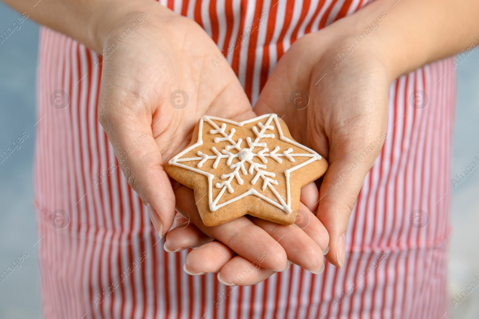 Photo of Woman holding tasty homemade Christmas cookie decorated with icing, closeup