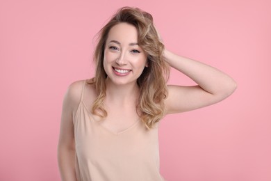 Photo of Portrait of smiling woman on pink background