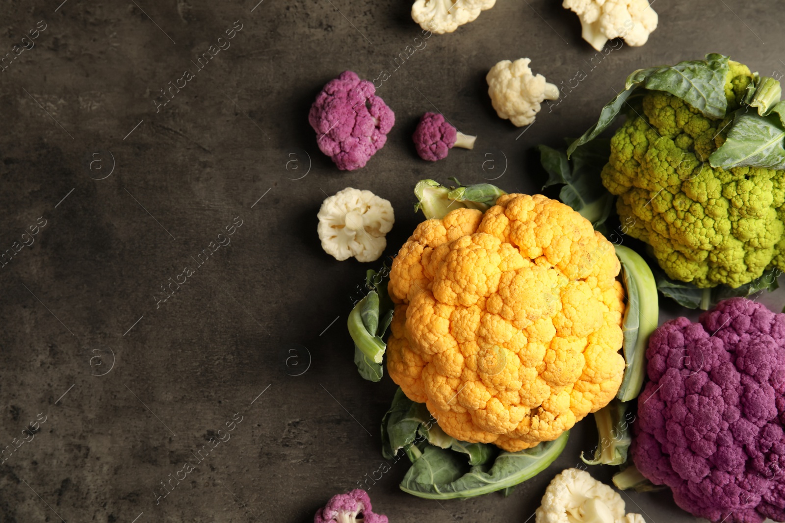 Photo of Colorful cauliflower cabbages on table, top view. Healthy food