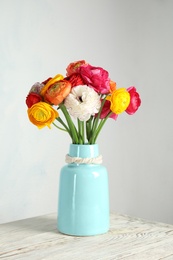 Photo of Vase with beautiful ranunculus flowers on table