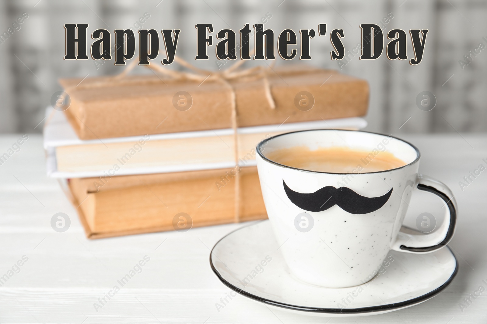 Image of Cup with paper moustache and books on white wooden table. Happy Father's Day