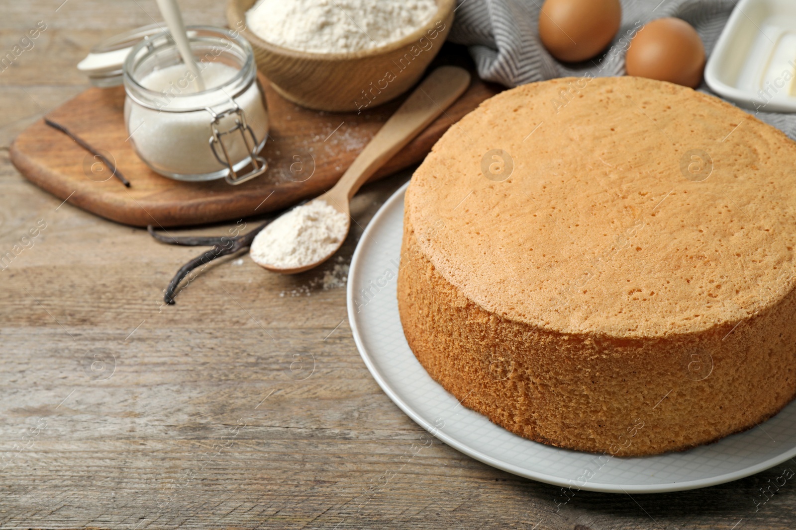 Photo of Delicious fresh homemade cake and ingredients on wooden table