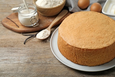 Delicious fresh homemade cake and ingredients on wooden table