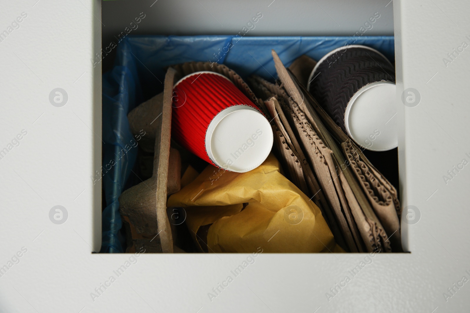 Photo of Closeup of metal bin with garbage, top view. Waste recycling