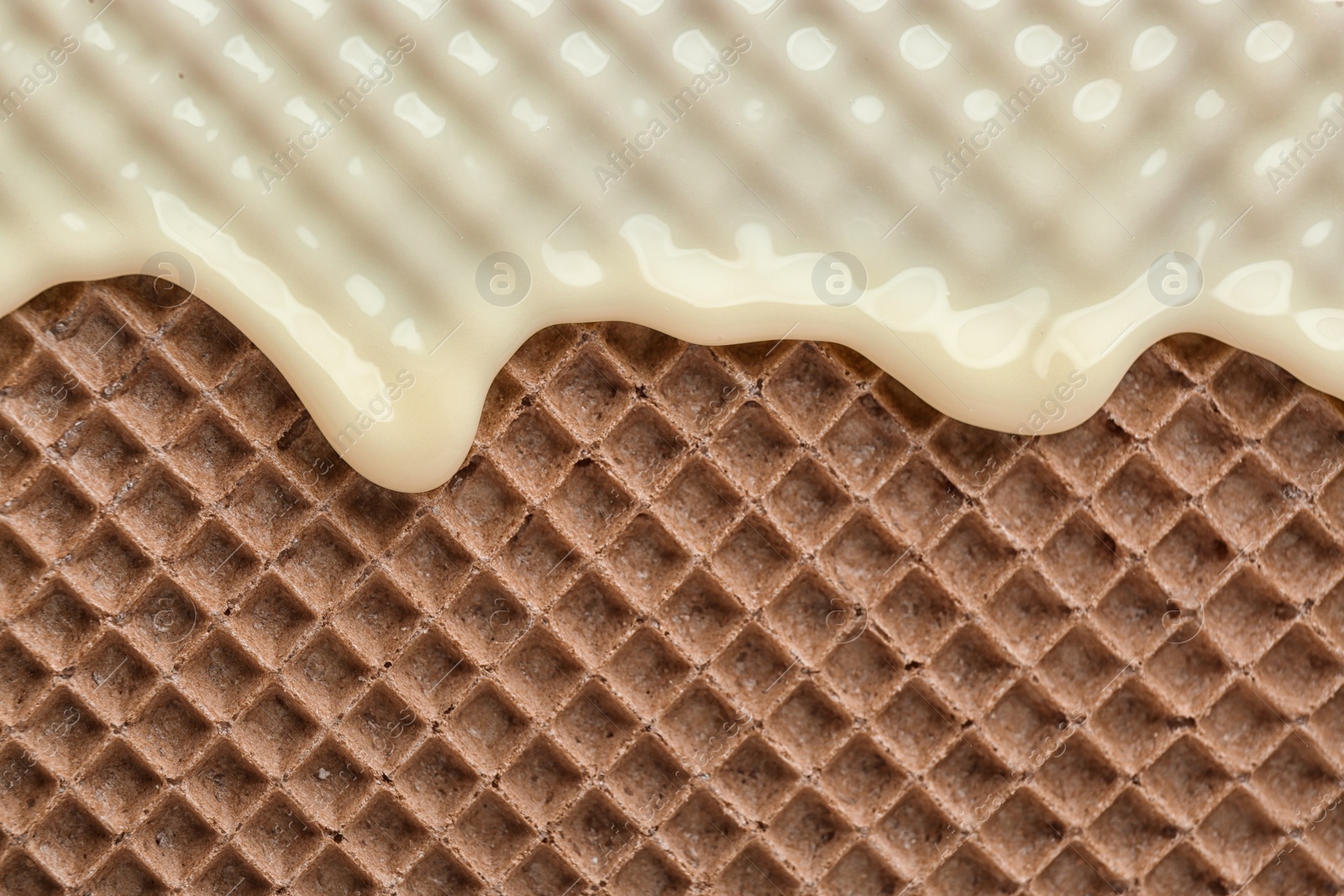 Photo of Hot white chocolate on wafer, closeup. Crispy food