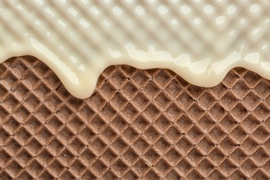 Hot white chocolate on wafer, closeup. Crispy food