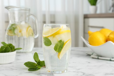 Photo of Delicious lemonade with mint on white marble table indoors