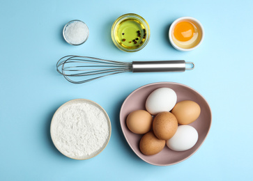 Flat lay composition with chicken eggs on light blue background