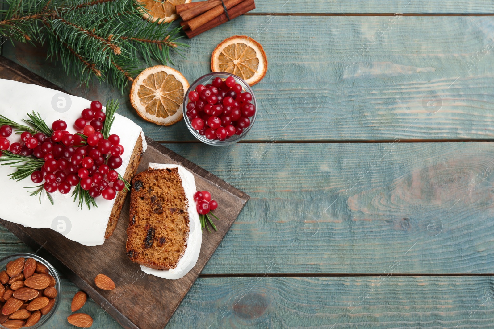 Photo of Traditional Christmas cake and ingredients on light blue wooden table, flat lay with space for text. Classic recipe