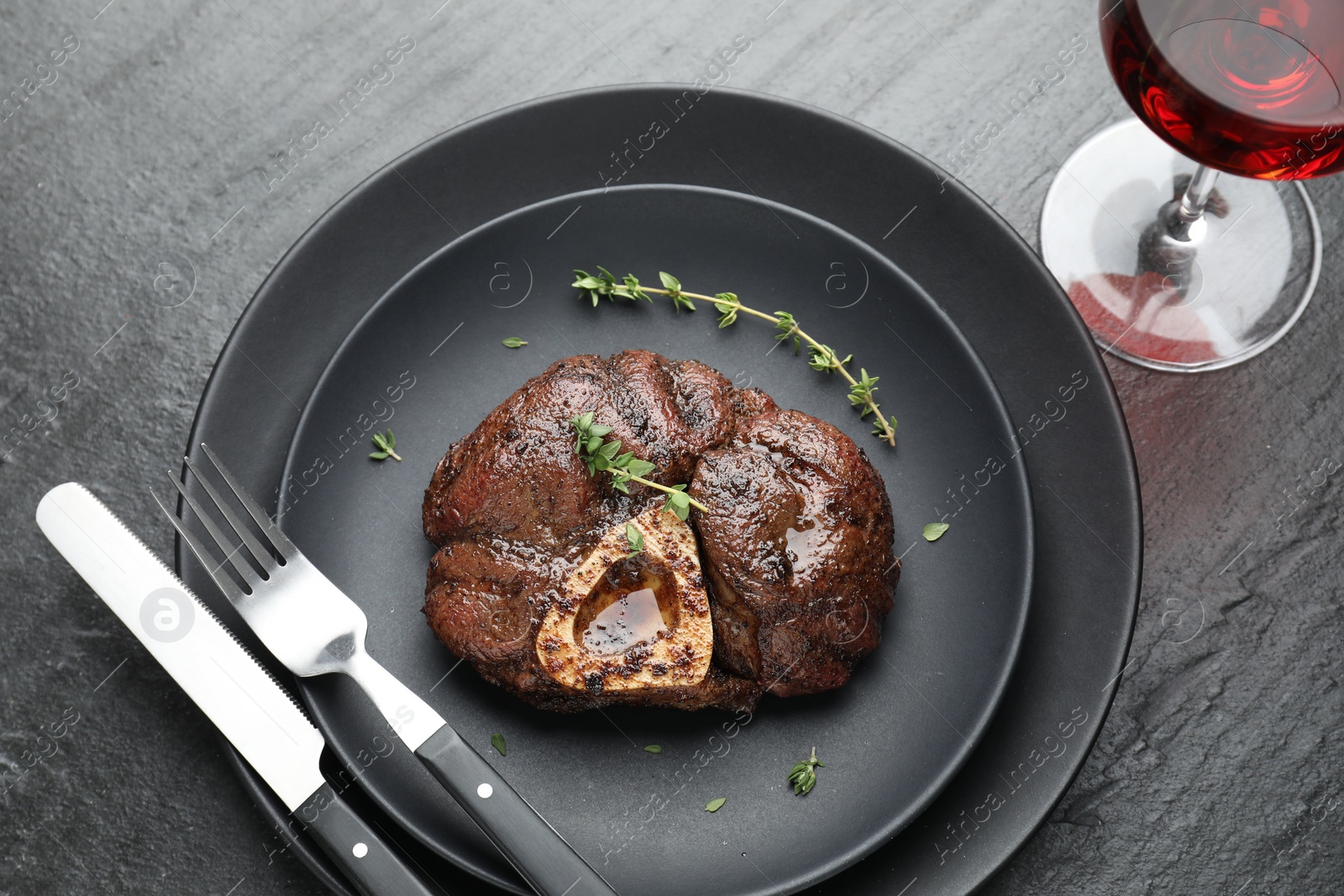 Photo of Tasty grilled beef meat served on black table, flat lay