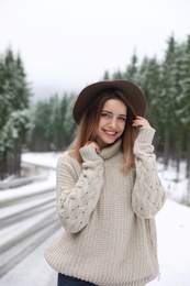 Photo of Young woman in warm sweater outdoors on snowy day. Winter vacation