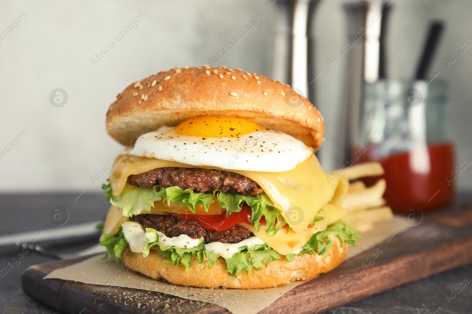 Photo of Tasty burger with fried egg on wooden board