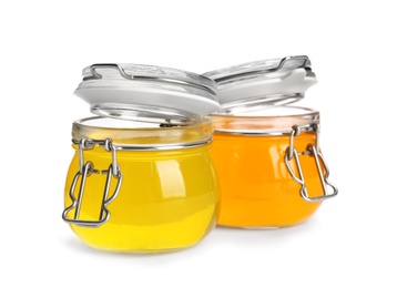 Tasty jelly desserts in glass jars on white background