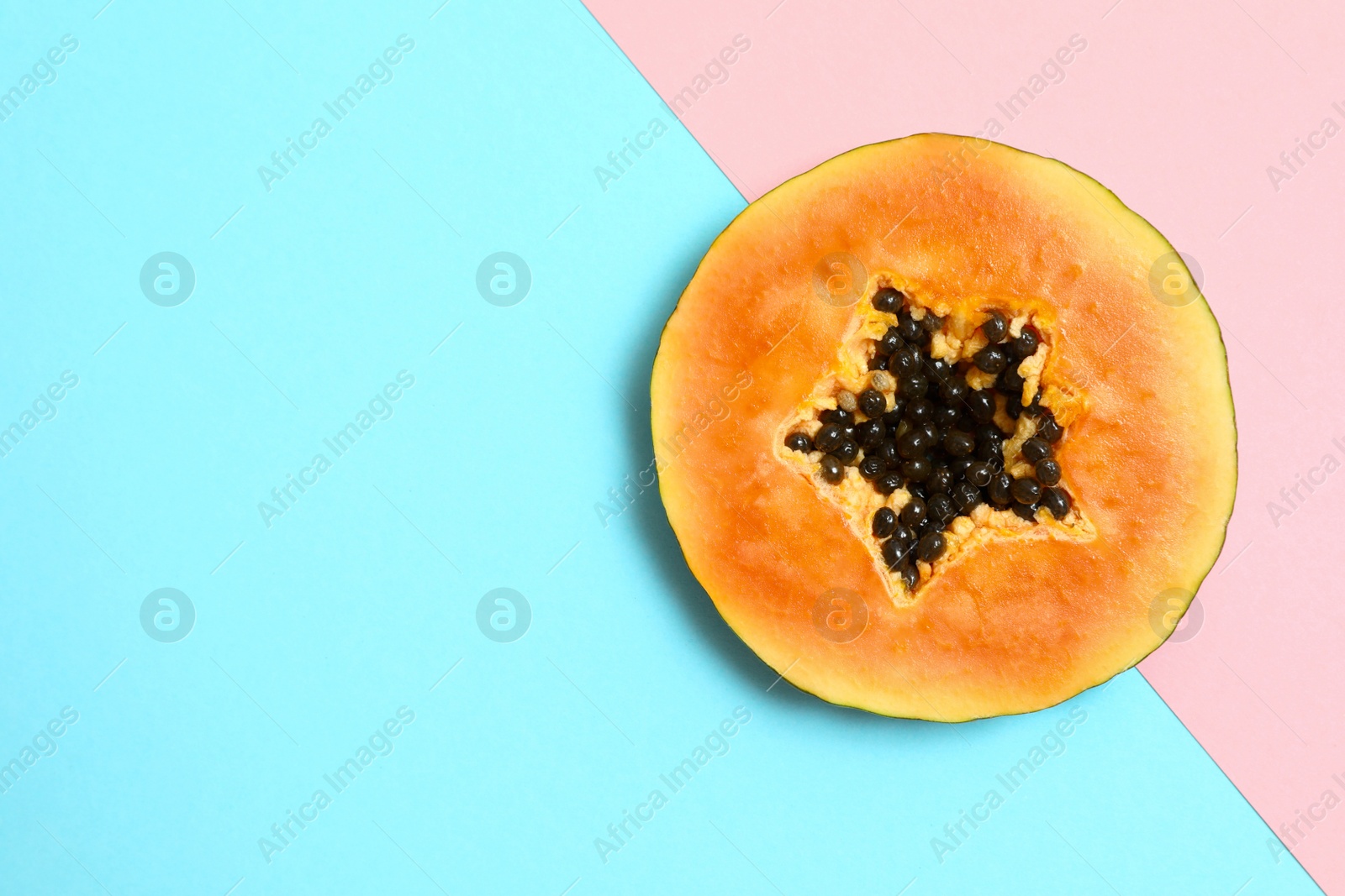 Photo of Slice of papaya on color background, top view. Space for text