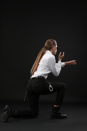 Photo of Female security guard using portable radio transmitter on dark background