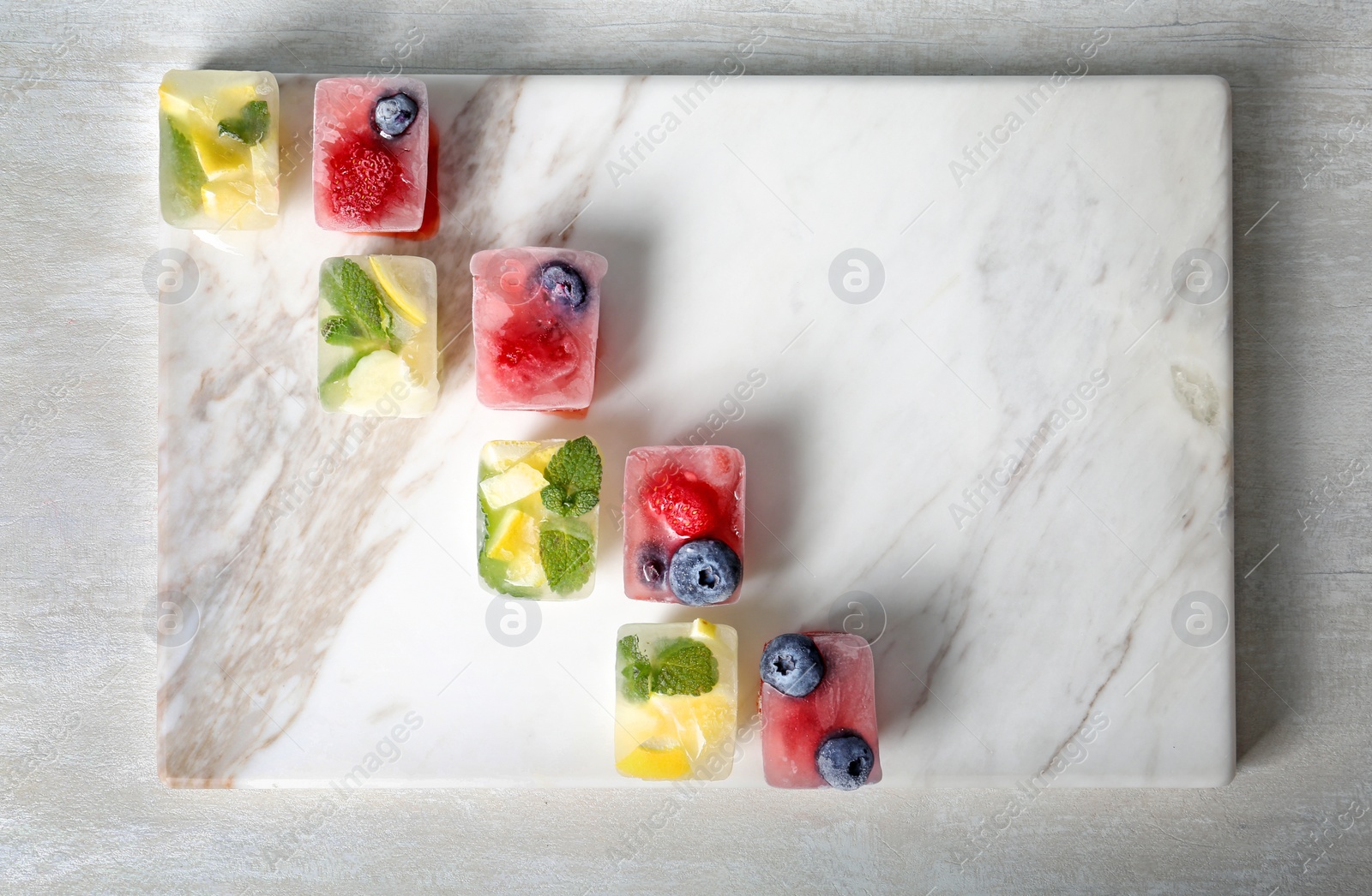 Photo of Flat lay composition with fruit and berry ice cubes on table. Space for text