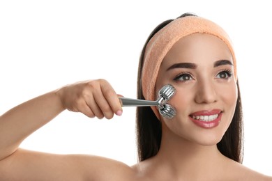 Photo of Woman using metal face roller on white background