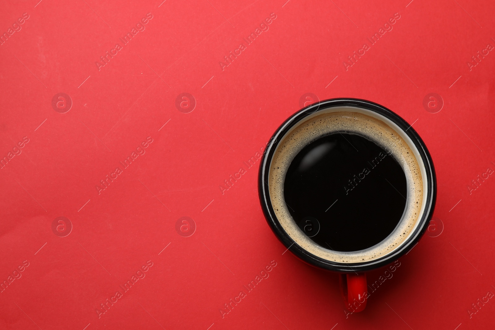 Photo of Fresh coffee in cup on red background, top view. Space for text