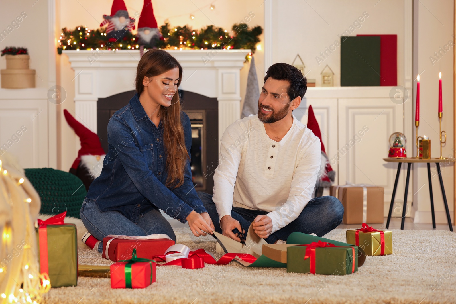 Photo of Happy couple decorating Christmas gifts at home