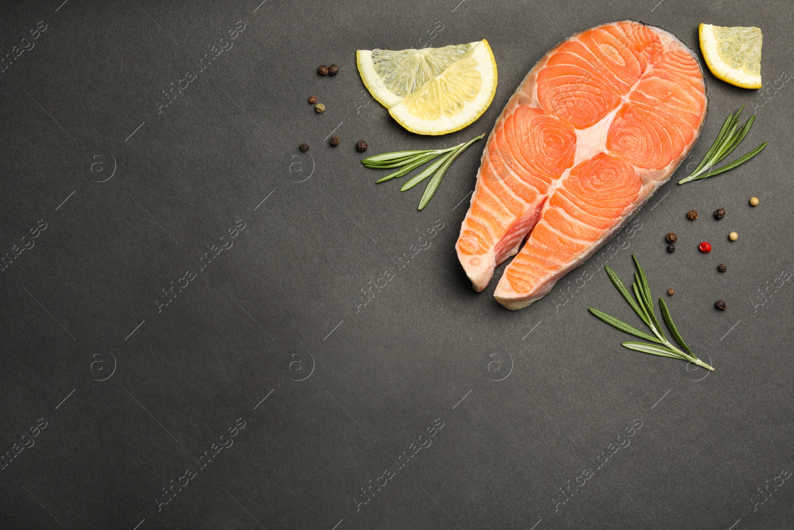 Photo of Flat lay composition with salmon steak on black background. Space for text