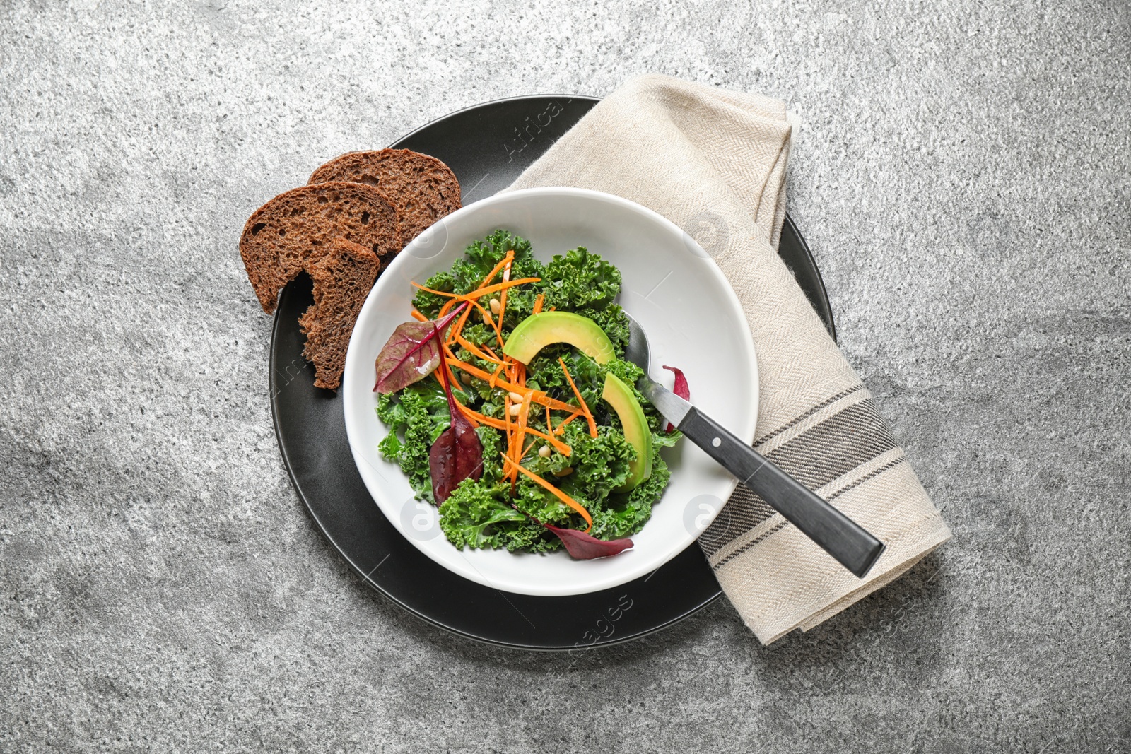 Photo of Tasty fresh kale salad on grey table, top view