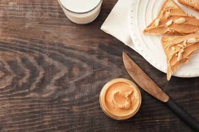 Photo of Jar with creamy peanut butter on table