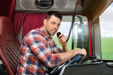 Photo of Driver using CB radio in cab of modern truck