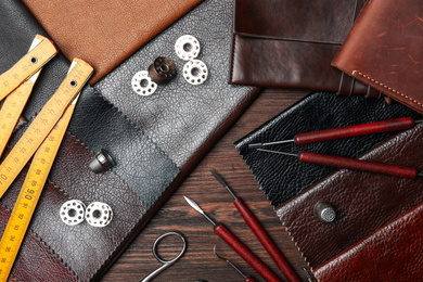 Photo of Flat lay composition with leather samples and tools on  wooden table