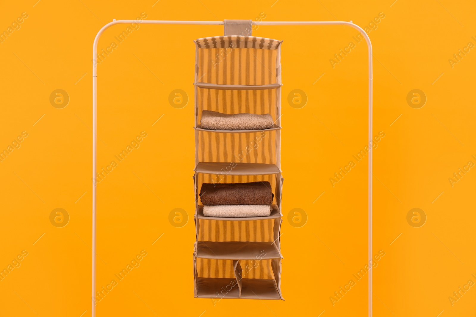 Photo of Foldable organizer on rack against yellow background