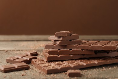 Photo of Pieces of tasty chocolate on wooden table