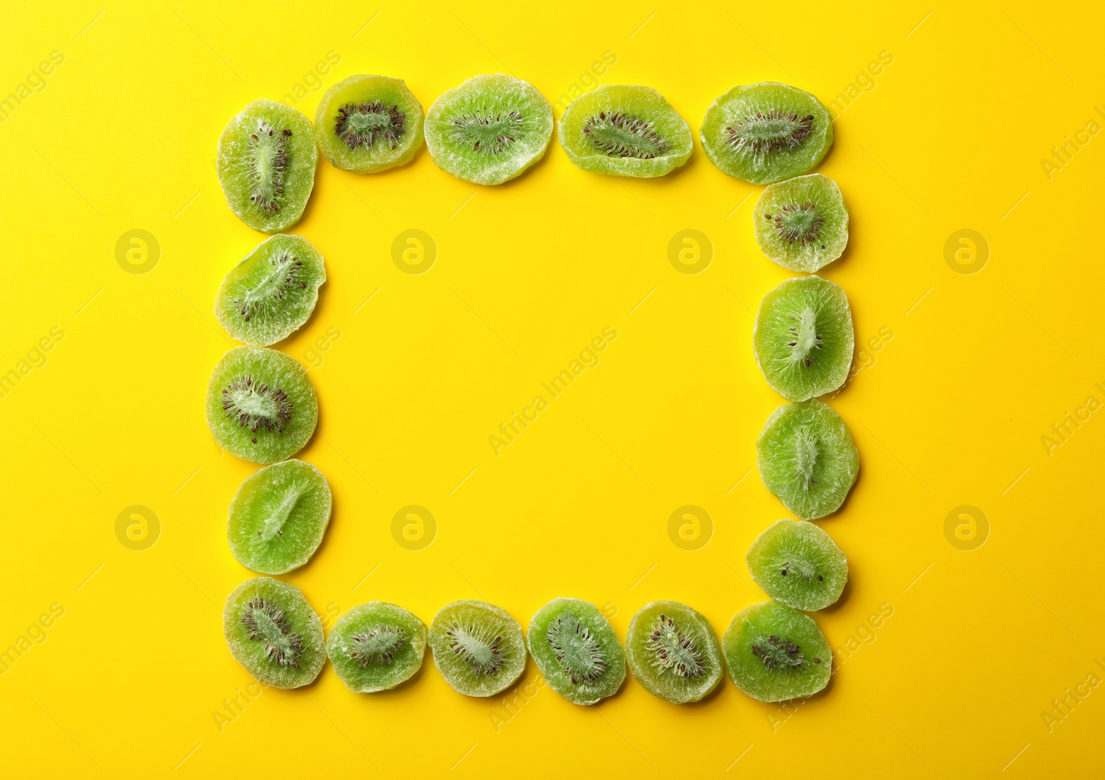 Photo of Frame made of kiwi on color background, top view with space for text. Dried fruit as healthy food