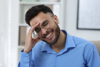 Portrait of handsome young man laughing in office