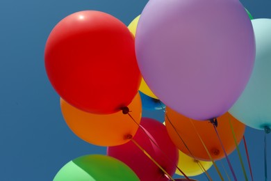 Photo of Bunch of colorful balloons against blue sky, closeup