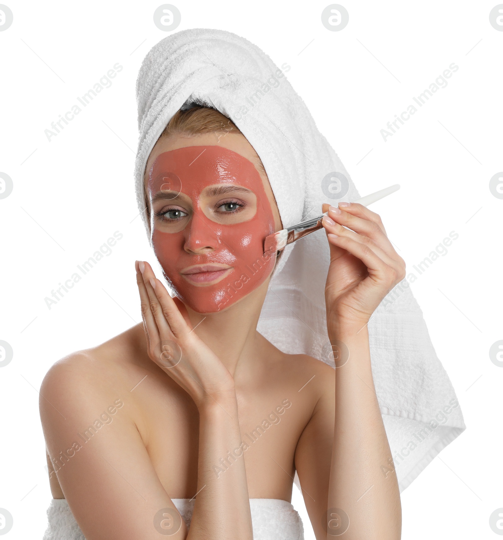 Photo of Young woman applying pomegranate face mask on white background