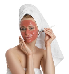 Photo of Young woman applying pomegranate face mask on white background