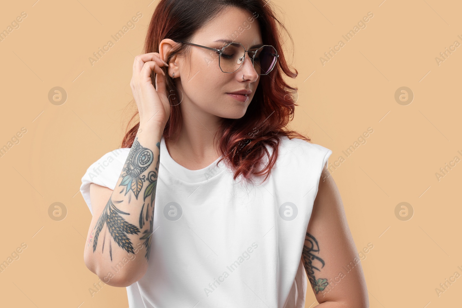 Photo of Portrait of beautiful tattooed woman on beige background