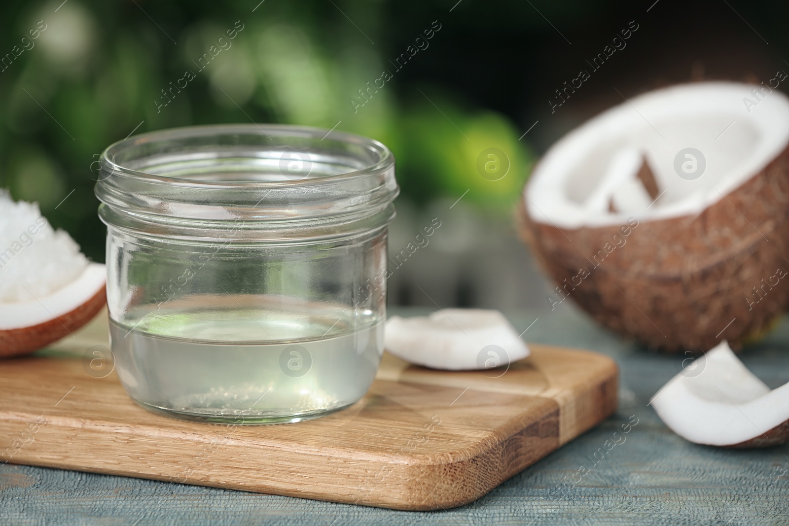 Photo of Coconut oil on light blue wooden table