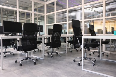 Photo of Comfortable office chairs and tables in meeting room