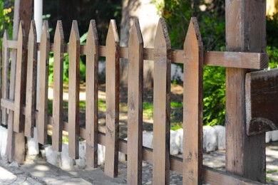 Photo of Wooden fence outdoors on sunny day, closeup