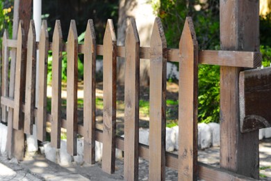 Wooden fence outdoors on sunny day, closeup