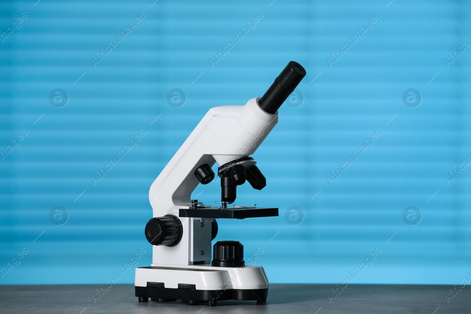 Photo of Modern medical microscope on grey table indoors