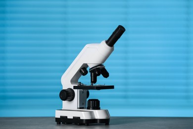 Photo of Modern medical microscope on grey table indoors