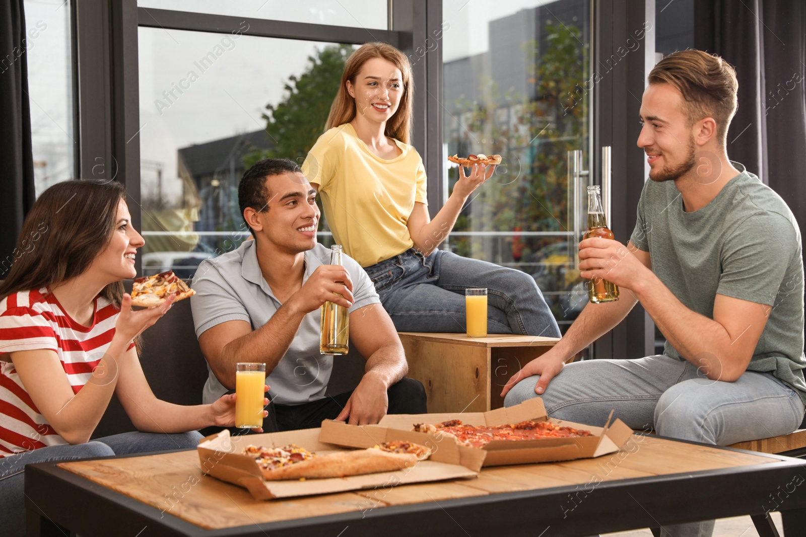 Photo of Group of friends having fun party with delicious pizza in cafe